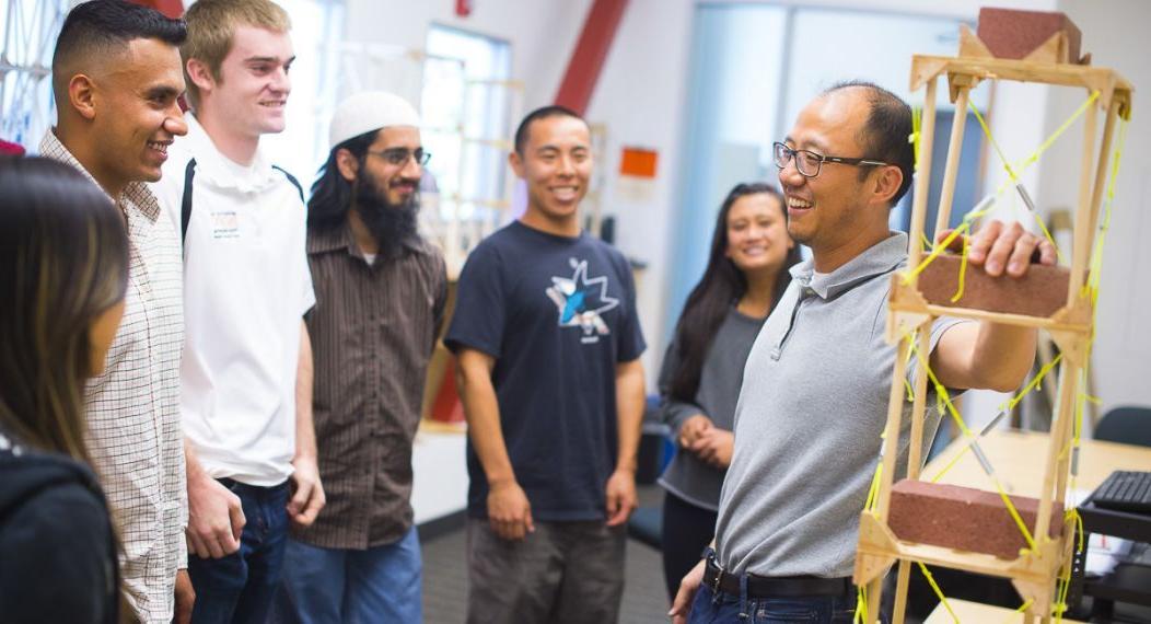 A professor talking with students in a lab.